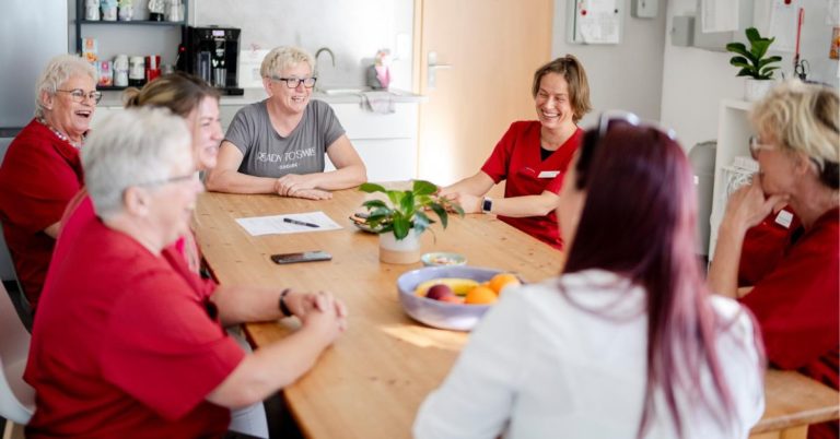 Mitarbeitende des ambulanten Pflegedienstes PuG Lembeck bei einer Besprechung in entspannter und fröhlicher Atmosphäre. Foto: PuG Lembeck