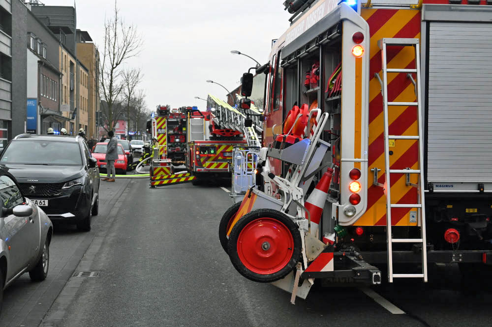 Dichter Rauch im Gebäude

Nach ersten Meldungen war die Feuerwehr zu einem gemeldeten Kellerbrand alarmiert worden. Vor Ort stellten die Einsatzkräfte jedoch eine deutlich verschärfte Lage fest. Dichter Rauch zog zeitweise durch das gesamte Gebäude. Mehrere Personen befanden sich im Haus und mussten gerettet sowie medizinisch versorgt werden. Die Feuerwehr leitete umgehend eine Menschenrettung ein und brachte die Bewohner ins Freie.

MANV der Stufe 10 ausgelöst

Aufgrund der Zahl der Betroffenen rief die Einsatzleitung einen Massenanfall von Verletzten der Stufe 10 aus. Damit wurde zusätzliche Unterstützung aus umliegenden Städten angefordert, um die Versorgung der Verletzten sicherzustellen.

„Wir sind zunächst von einem Kellerbrand ausgegangen. Vor Ort hat sich die Lage jedoch deutlich ausgeweitet“, erklärte Pressesprecher Jan Heppner. „Mehrere Personen mussten aus dem Gebäude gerettet und rettungsdienstlich versorgt werden.“

80 bis 100 Einsatzkräfte vor Ort

Nach Angaben der Feuerwehr waren im Verlauf des Einsatzes rund 80 bis 100 Kräfte von Feuerwehr und Rettungsdienst im Einsatz. Die starke Hitzeentwicklung im Keller erschwerte die Löscharbeiten erheblich. Mehrere Trupps gingen unter Atemschutz in das Gebäude vor.

„Wir rechnen damit, dass sich der Einsatz noch über mehrere Stunden hinzieht“, sagte Jan Heppner. Auch nach Abschluss der Löscharbeiten seien Nacharbeiten notwendig.

Straße gesperrt – Ursache noch unklar

Die Halterner Straße bleibt während des Einsatzes und der anschließenden Maßnahmen gesperrt. Zur Brandursache gibt es derzeit keine Angaben. Die Ermittlungen übernimmt die Polizei nach Abschluss der Löscharbeiten.