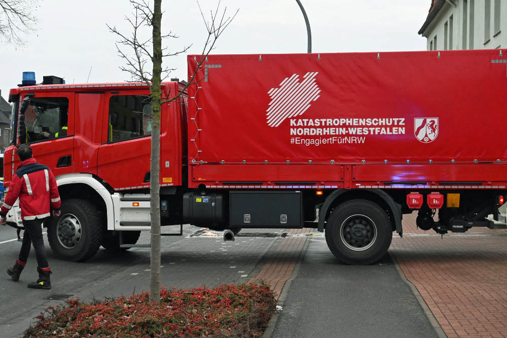Dichter Rauch im Gebäude

Nach ersten Meldungen war die Feuerwehr zu einem gemeldeten Kellerbrand alarmiert worden. Vor Ort stellten die Einsatzkräfte jedoch eine deutlich verschärfte Lage fest. Dichter Rauch zog zeitweise durch das gesamte Gebäude. Mehrere Personen befanden sich im Haus und mussten gerettet sowie medizinisch versorgt werden. Die Feuerwehr leitete umgehend eine Menschenrettung ein und brachte die Bewohner ins Freie.

MANV der Stufe 10 ausgelöst

Aufgrund der Zahl der Betroffenen rief die Einsatzleitung einen Massenanfall von Verletzten der Stufe 10 aus. Damit wurde zusätzliche Unterstützung aus umliegenden Städten angefordert, um die Versorgung der Verletzten sicherzustellen.

„Wir sind zunächst von einem Kellerbrand ausgegangen. Vor Ort hat sich die Lage jedoch deutlich ausgeweitet“, erklärte Pressesprecher Jan Heppner. „Mehrere Personen mussten aus dem Gebäude gerettet und rettungsdienstlich versorgt werden.“

80 bis 100 Einsatzkräfte vor Ort

Nach Angaben der Feuerwehr waren im Verlauf des Einsatzes rund 80 bis 100 Kräfte von Feuerwehr und Rettungsdienst im Einsatz. Die starke Hitzeentwicklung im Keller erschwerte die Löscharbeiten erheblich. Mehrere Trupps gingen unter Atemschutz in das Gebäude vor.

„Wir rechnen damit, dass sich der Einsatz noch über mehrere Stunden hinzieht“, sagte Jan Heppner. Auch nach Abschluss der Löscharbeiten seien Nacharbeiten notwendig.

Straße gesperrt – Ursache noch unklar

Die Halterner Straße bleibt während des Einsatzes und der anschließenden Maßnahmen gesperrt. Zur Brandursache gibt es derzeit keine Angaben. Die Ermittlungen übernimmt die Polizei nach Abschluss der Löscharbeiten.
