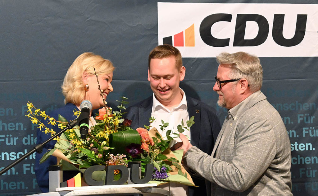 Jan Heppner und Holger Krajewski überreichen Kathrin Gödecke beim CDU-Neujahrsempfang in Dorsten einen Blumenstrauß.