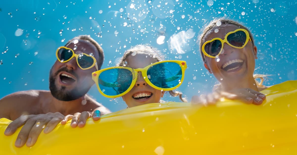 Familie mit gelbem Schwimmring als Symbolbild für Sommer, Wasser und Freizeit