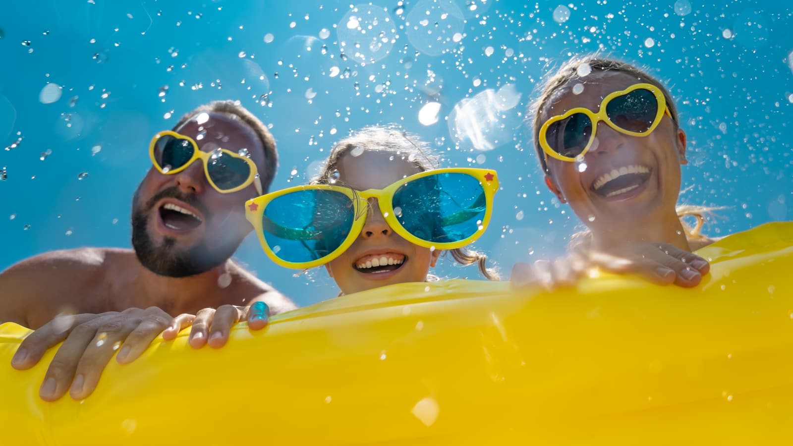 Familie mit gelbem Schwimmring als breites Sommermotiv für das Freizeitspezial